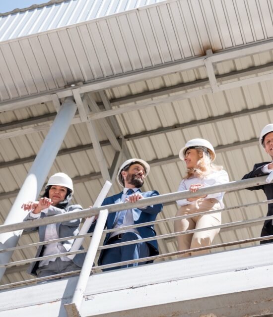 team of contractors in formal wear talking at construction site