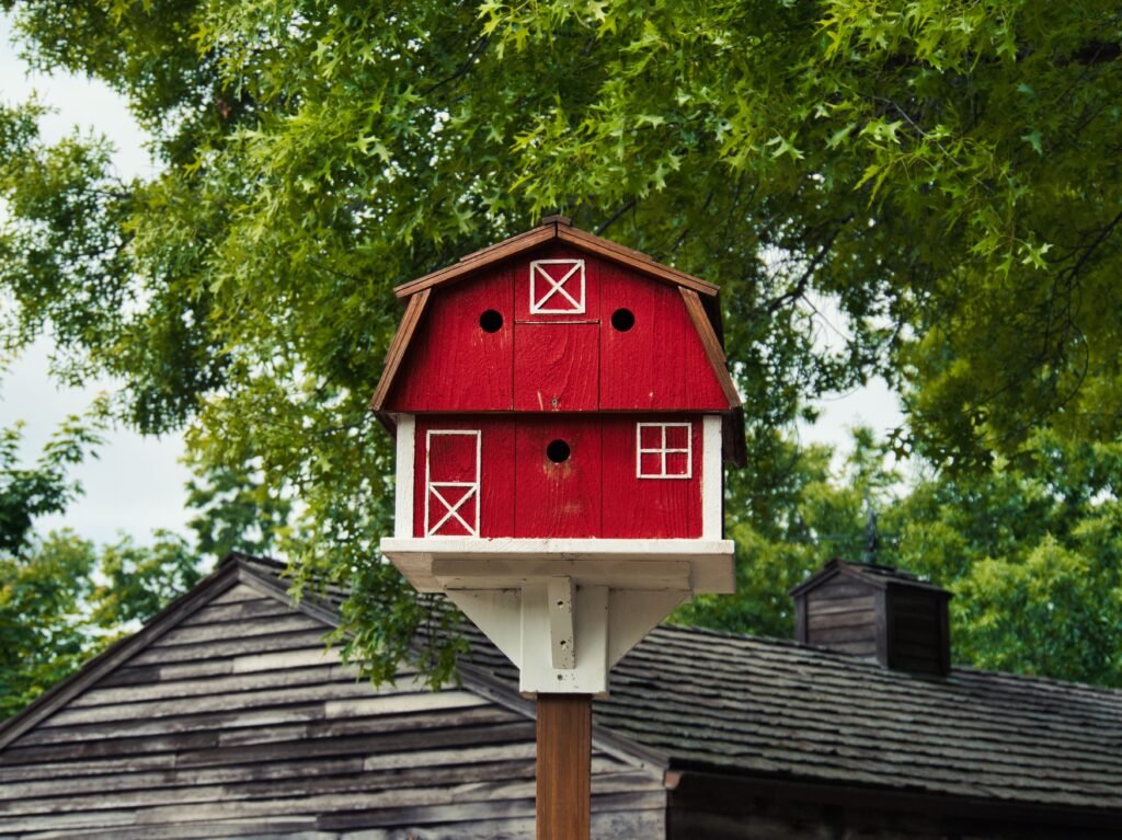 A closeup of a cute red barn birdhouse at Deanna Rose Farmstead in Overland park Kansas